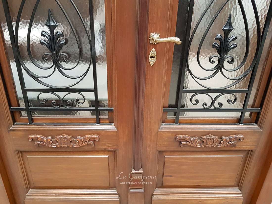 Puerta doble con reja y tallado a mano