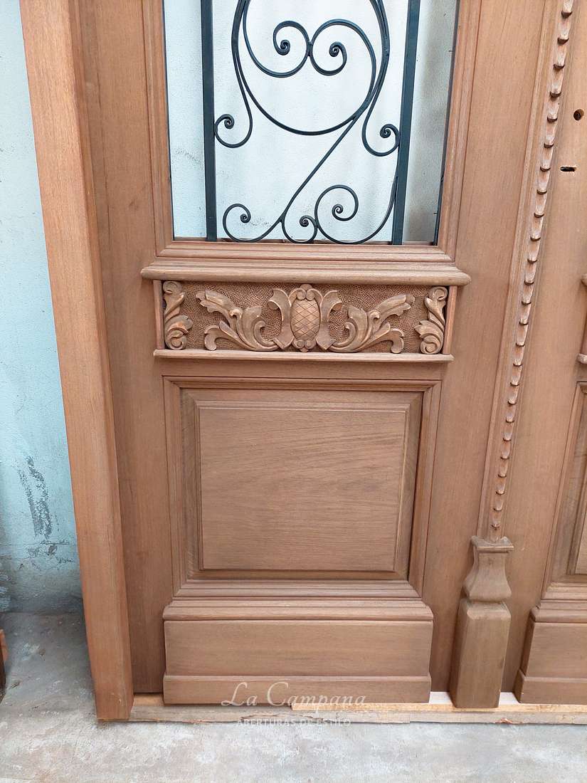 Puerta de cedro con tablero y reja