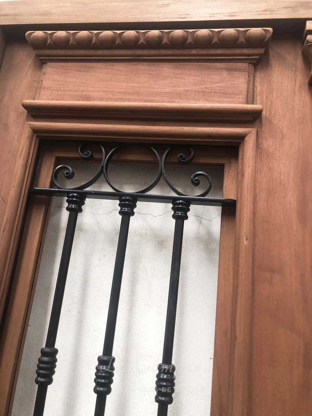 Puerta doble tallada con reja